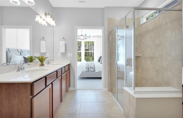 bathroom with a healthy amount of sunlight, an enclosed shower, tile flooring, and dual vanity