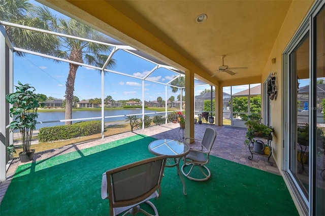 view of patio featuring a ceiling fan, a lanai, and a water view