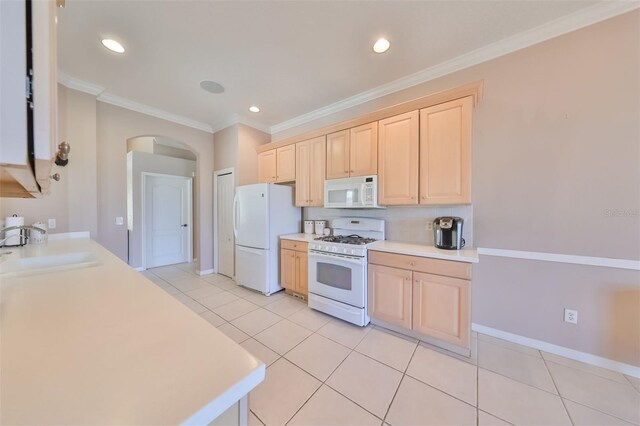 kitchen with white appliances, arched walkways, crown molding, light brown cabinets, and a sink