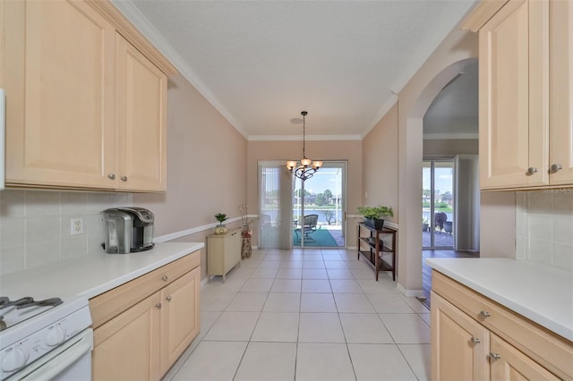 kitchen featuring arched walkways, light countertops, light brown cabinetry, and white range with gas stovetop