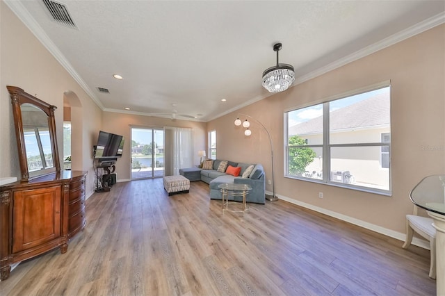 living area featuring ornamental molding, visible vents, light wood-style flooring, and baseboards