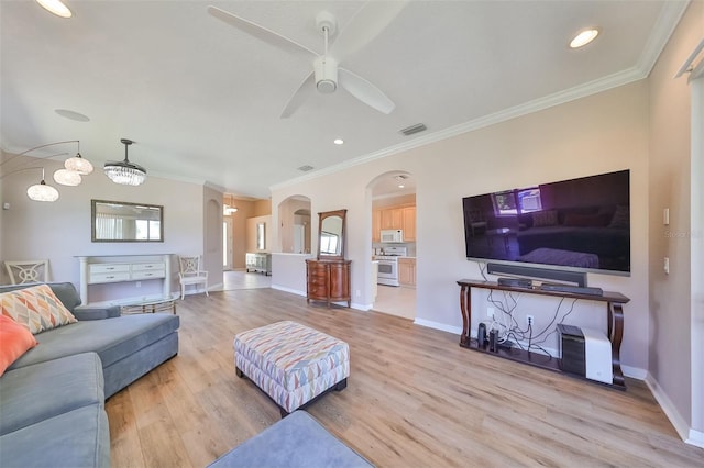 living room featuring arched walkways, light wood-type flooring, visible vents, and crown molding