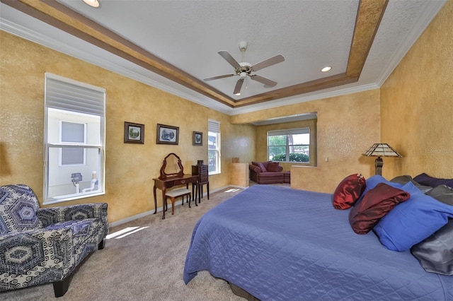 carpeted bedroom with baseboards, a raised ceiling, a textured wall, ceiling fan, and crown molding