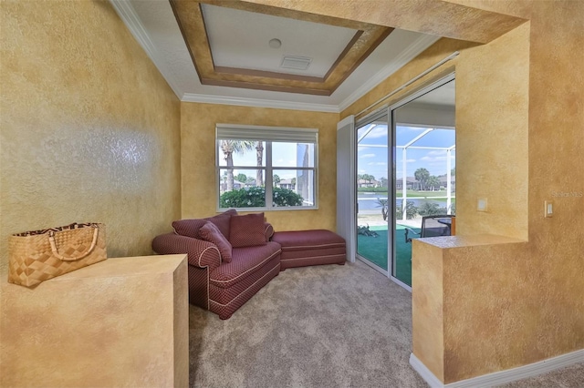 living area featuring a tray ceiling, carpet, crown molding, visible vents, and a textured wall