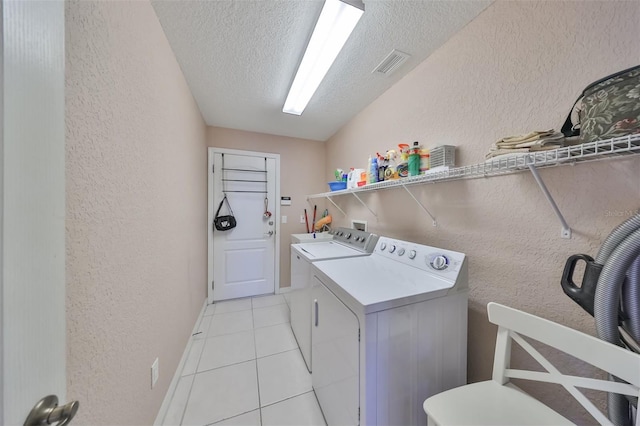 laundry room featuring laundry area, visible vents, washer and dryer, and a textured wall