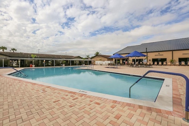 community pool featuring a patio and fence