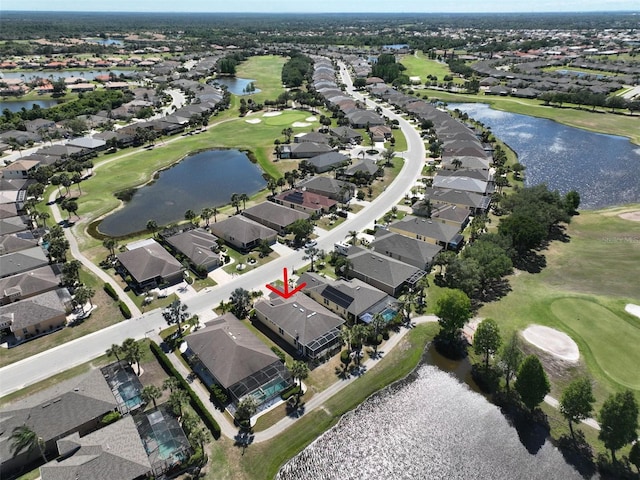 drone / aerial view with a water view, a residential view, and golf course view