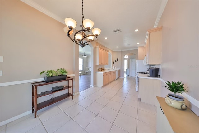 kitchen with arched walkways, light brown cabinets, visible vents, light countertops, and crown molding