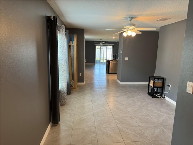 hall featuring a textured ceiling and light tile flooring