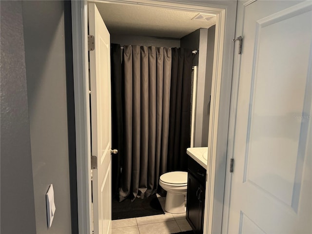 bathroom with tile floors, vanity, and toilet