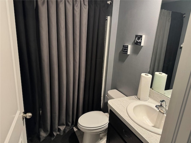 bathroom featuring vanity with extensive cabinet space and toilet