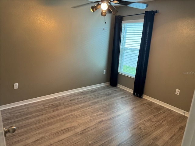 empty room with ceiling fan and hardwood / wood-style flooring