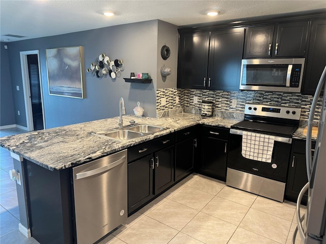 kitchen with sink, backsplash, light tile floors, and stainless steel appliances