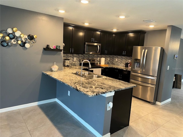 kitchen featuring backsplash, light tile floors, and stainless steel appliances