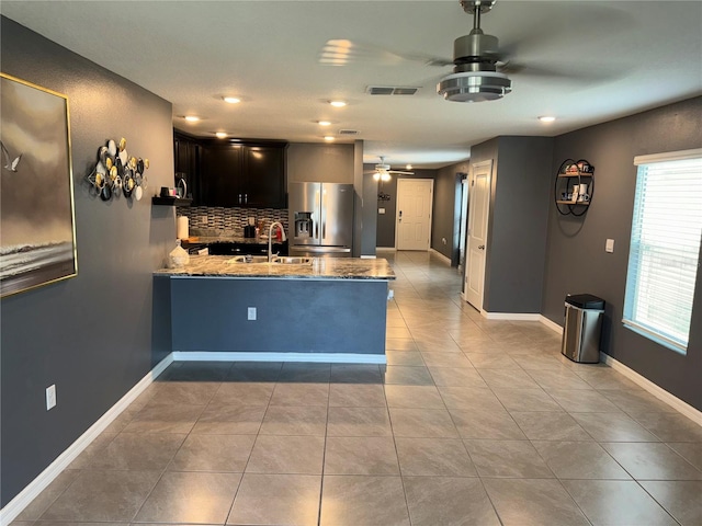 kitchen with backsplash, ceiling fan, light tile floors, and stainless steel fridge