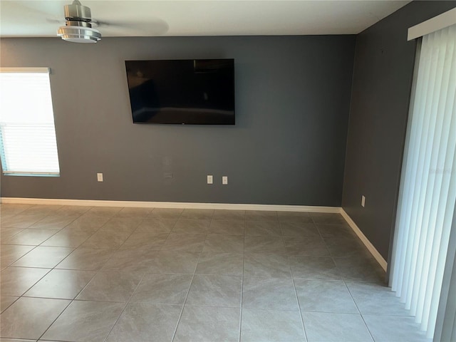 tiled spare room featuring ceiling fan