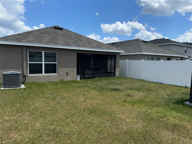 back of property with a yard, central AC unit, and a sunroom