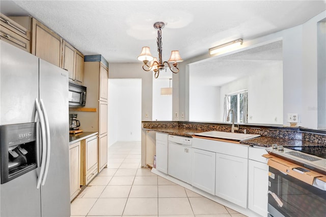 kitchen with hanging light fixtures, black appliances, sink, and light tile flooring