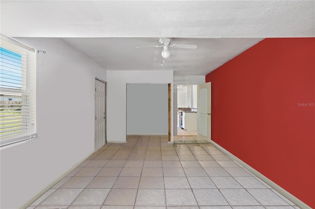 tiled empty room with a textured ceiling and ceiling fan