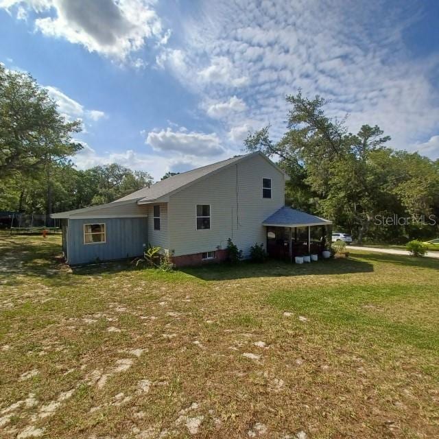 rear view of house featuring a yard