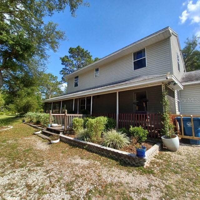 rear view of property with covered porch