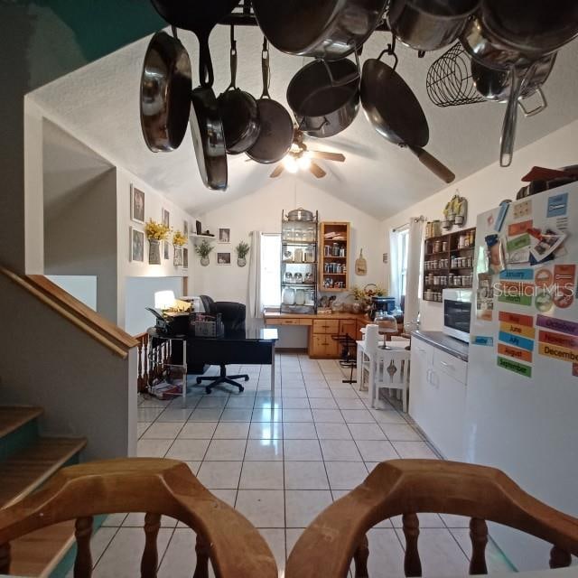 kitchen featuring ceiling fan, light tile patterned flooring, white appliances, vaulted ceiling, and a healthy amount of sunlight