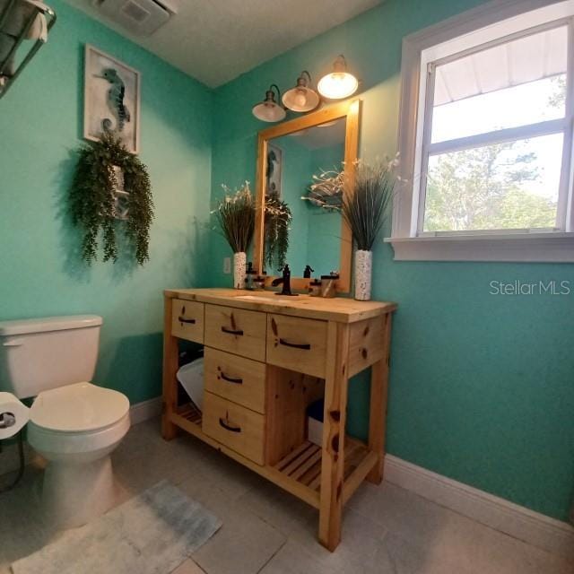 bathroom with tile patterned flooring, vanity, and toilet