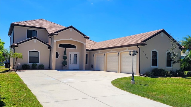 mediterranean / spanish-style house featuring a front lawn, central air condition unit, and a garage