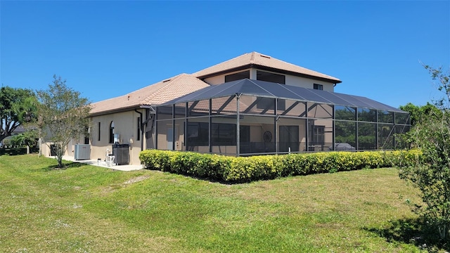 back of property with cooling unit, a lawn, and a lanai