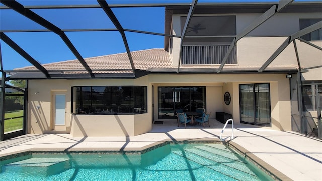 back of property featuring glass enclosure and a patio area