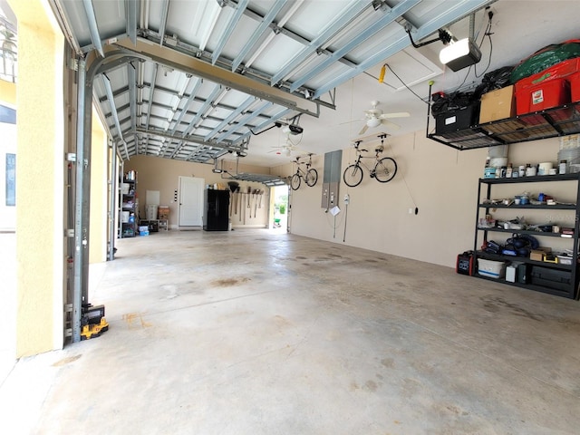 garage with a garage door opener, ceiling fan, and electric panel