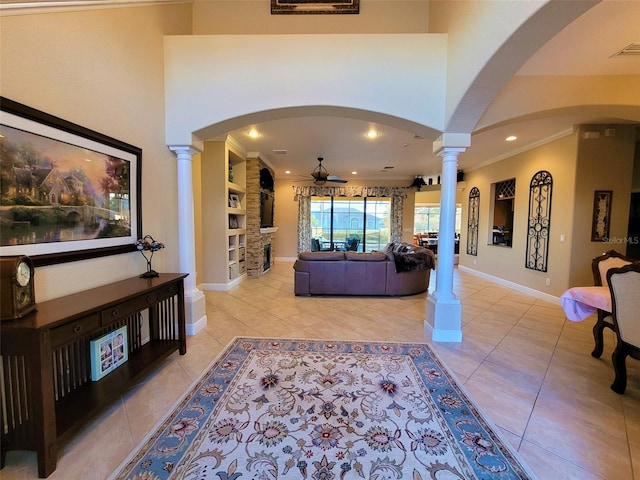 living room with ornamental molding, built in shelves, and light tile patterned floors