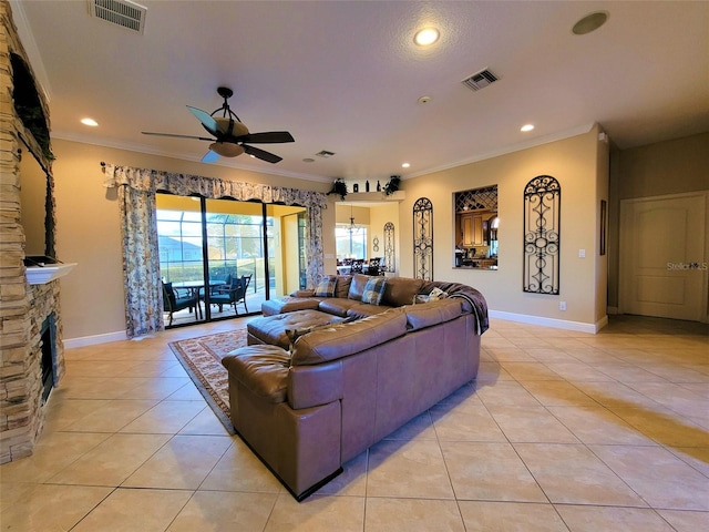 living room featuring ornamental molding, a fireplace, light tile patterned flooring, and ceiling fan