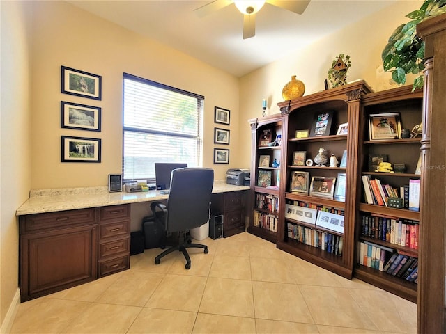 tiled office space with built in desk and ceiling fan