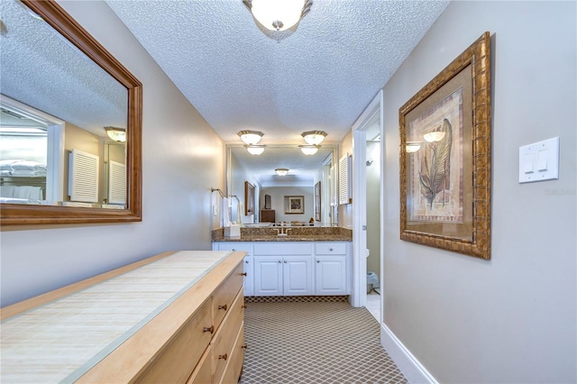 bathroom with a textured ceiling, vanity, and tile flooring