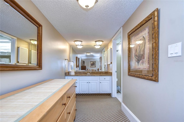 bathroom featuring a textured ceiling, vanity, and tile floors