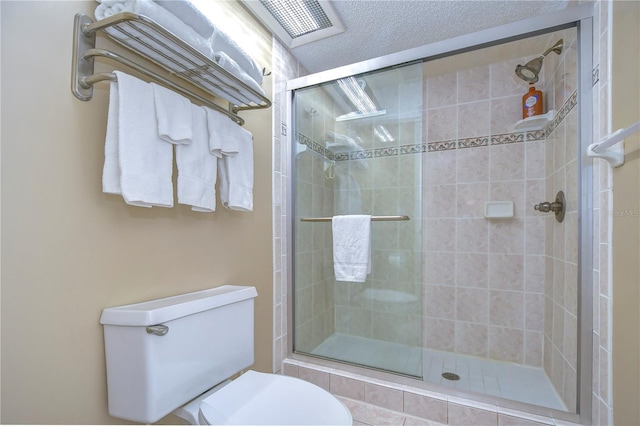 bathroom with a shower with shower door and toilet