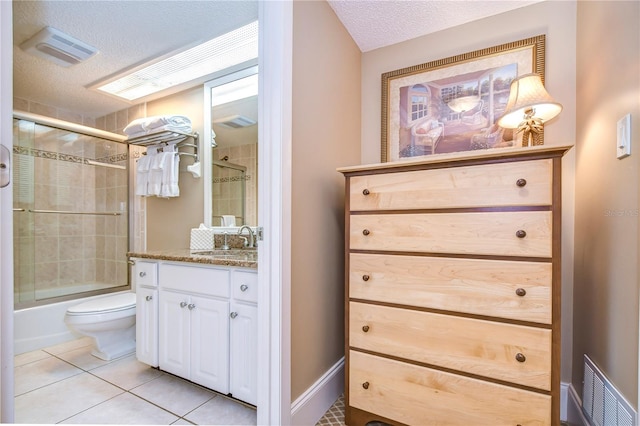 full bathroom featuring toilet, combined bath / shower with glass door, tile flooring, a textured ceiling, and vanity