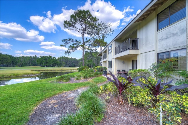 surrounding community with a yard and a water view