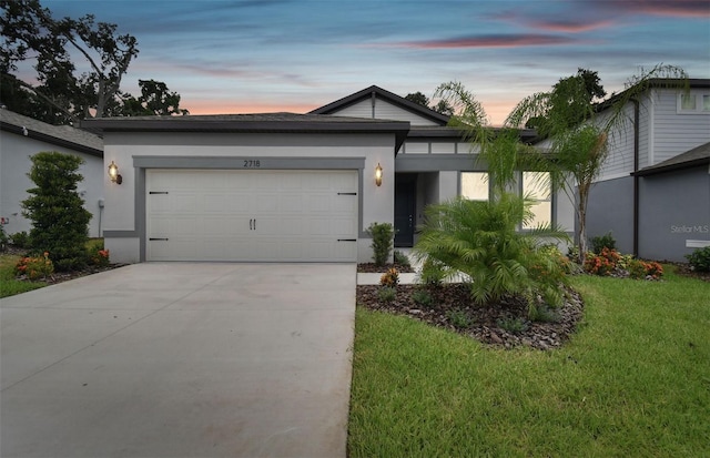 single story home featuring a garage and a yard