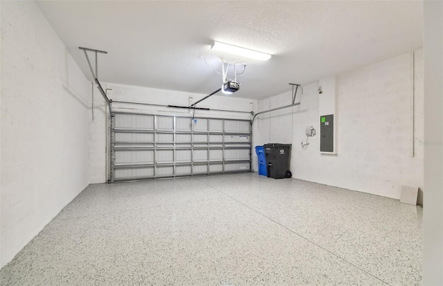 garage with a garage door opener and electric panel