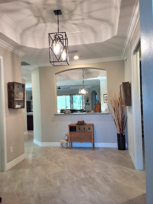 interior space with an inviting chandelier, tile flooring, crown molding, and a raised ceiling