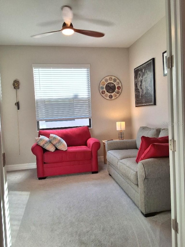 carpeted living room with ceiling fan