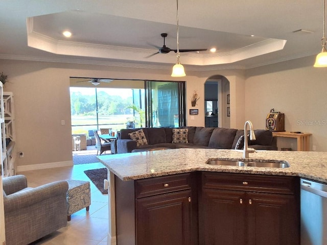 kitchen featuring a tray ceiling, ceiling fan, sink, and light tile flooring