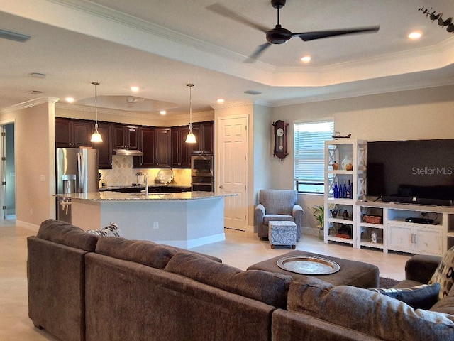 tiled living room featuring sink, ceiling fan, crown molding, and a tray ceiling