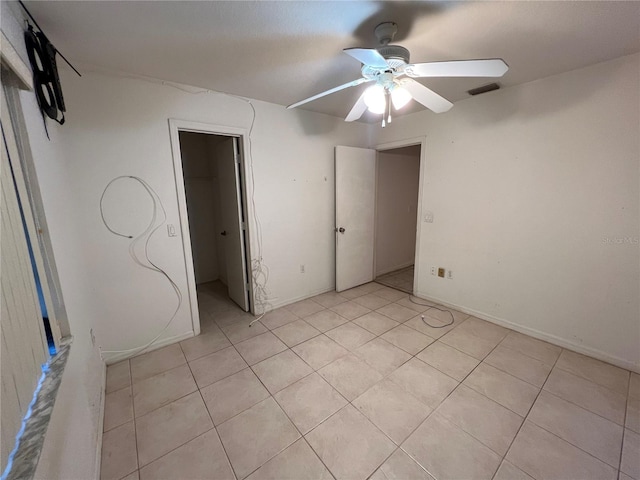 tiled spare room with ceiling fan