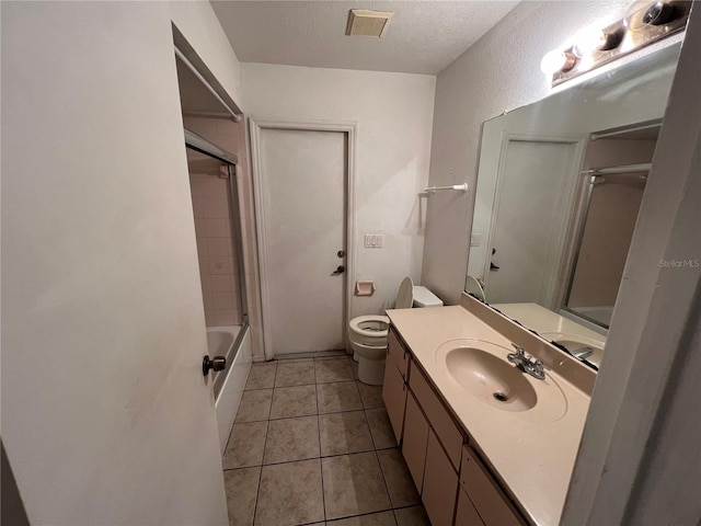 full bathroom with bathing tub / shower combination, large vanity, tile flooring, toilet, and a textured ceiling