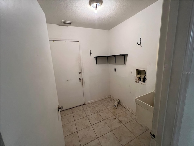 laundry room featuring a textured ceiling, washer hookup, light tile floors, and electric dryer hookup