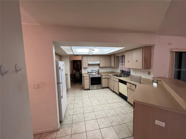 kitchen with kitchen peninsula, white appliances, light tile flooring, a skylight, and sink