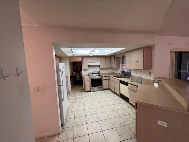 kitchen with kitchen peninsula, white appliances, a skylight, sink, and light tile floors